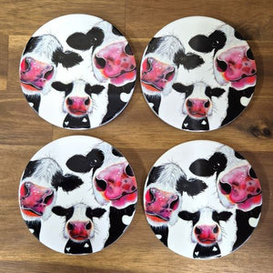 Protect your tabletops with our high-quality ceramic Cow Table Bar Coasters. This set of 4 boxed round coasters features a cute three cow cartoon image, adding a touch of charm to your home decor. Enjoy functional and stylish coasters that are perfect for any tabletop or bar setting.  Set of 4 coasters - same image | Round 10 cm diameter | Gloss protective front | Cork non slip backing | Boxed in our white coaster box with lid.