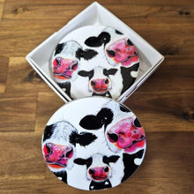 Load image into Gallery viewer, Protect your tabletops with our high-quality ceramic Cow Table Bar Coasters. This set of 4 boxed round coasters features a cute three cow cartoon image, adding a touch of charm to your home decor. Enjoy functional and stylish coasters that are perfect for any tabletop or bar setting.  Set of 4 coasters - same image | Round 10 cm diameter | Gloss protective front | Cork non slip backing | Boxed in our white coaster box with lid.