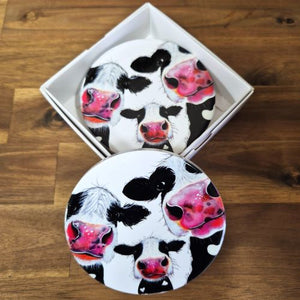 Protect your tabletops with our high-quality ceramic Cow Table Bar Coasters. This set of 4 boxed round coasters features a cute three cow cartoon image, adding a touch of charm to your home decor. Enjoy functional and stylish coasters that are perfect for any tabletop or bar setting.  Set of 4 coasters - same image | Round 10 cm diameter | Gloss protective front | Cork non slip backing | Boxed in our white coaster box with lid.