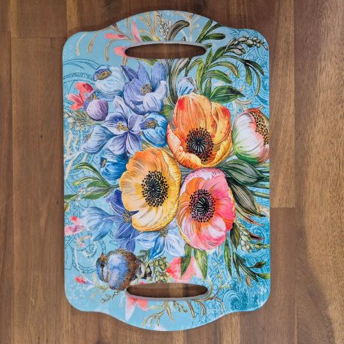 Expertly crafted garden serving tray with a beautiful blue bird design. This ceramic table tray features two hand grips for easy carrying and serving. Perfect for adding a touch of nature to your kitchen or dining table. Functional and decorative, it's a must-have for any bird or flower lover.  Ceramic | 28 x 18 cm | Gloss finish | Cork non slip backing | Two hand grips