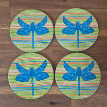 Load image into Gallery viewer, Add a touch of nature to your table with our Dragonfly Coasters! This set of 4 round coasters features beautiful and colourful dragonflies, adding a pop of color to any table. Protect your surfaces while also adding a stylish and unique touch to your home decor.  Colourful as shown | Round | 10 cm diameter | Set of 4 - same design | White gift box with lid | Glossy finish | Cork non slip backing.&nbsp;