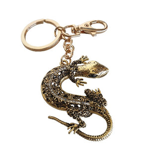 Add a touch of good luck to your everyday life with our Gecko Keyring Gift. Made of silver and blue metal, this keychain features a charming gecko design, symbolizing good fortune and prosperity. Carry it with you or gift it to a loved one for a daily reminder of luck and blessings.  Gecko 5 x 6 cm | Gold metal keychain -&nbsp; full length 12 cm |&nbsp;&nbsp;Blue rhinestones | Comes in a beautiful cotton organza gift bag - colours will vary