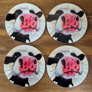 Protect your tables with this Cow Table Bar Coasters set. Featuring a cute and curious cow cartoon image, these ceramic coasters come in a boxed gift set of 4. Keep your surfaces safe and add a touch of whimsy with these adorable coasters.  Set of 4 coasters - same image | Round 10 cm diameter | Gloss protective front | Cork non slip backing | Boxed in our white coaster box with lid.