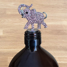 Load image into Gallery viewer, Black bottle with a decorative elephant bottle stopper on a wooden surface