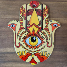 Load image into Gallery viewer, This multi-functional Hamsa Hand Of Protection serves as a trivet, plate, and hanging sign. Made from colorful ceramic, it adds a touch of charm to any kitchen or room. The Hamsa hand symbol offers protection and good luck, making it a meaningful and thoughtful gift.  In all faiths it is a protective sign. It brings it&#39;s owner happiness, luck, health, and good fortune.