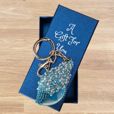 this exquisite large shell bag charm keyring makes an ideal gift for ocean enthusiasts. Expertly handcrafted with rhinestone pearls and stones, it features a gold metal chain measuring 14 cm in length, with the shell sized at 7 x 3.5 cm.