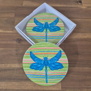 Add a touch of nature to your table with our Dragonfly Coasters! This set of 4 round coasters features beautiful and colourful dragonflies, adding a pop of color to any table. Protect your surfaces while also adding a stylish and unique touch to your home decor.  Colourful as shown | Round | 10 cm diameter | Set of 4 - same design | White gift box with lid | Glossy finish | Cork non slip backing.&nbsp;