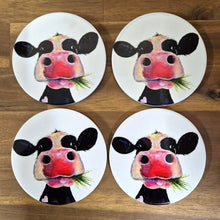 Load image into Gallery viewer, Enhance your table or bar with these adorable Cow Table Bar Coasters. Featuring a cute cartoon cow grazing on grass, this set of four ceramic coasters is the perfect gift for any cow lover. Protect your surfaces while bringing a touch of whimsy to any space.  Set of 4 coasters - same image | Round 10 cm diameter | Gloss protective front | Cork non slip backing | Boxed in our white coaster box with lid.