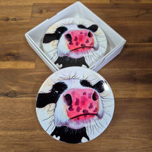 Load image into Gallery viewer, Protect your tables with this Cow Table Bar Coasters set. Featuring a cute and curious cow cartoon image, these ceramic coasters come in a boxed gift set of 4. Keep your surfaces safe and add a touch of whimsy with these adorable coasters.  Set of 4 coasters - same image | Round 10 cm diameter | Gloss protective front | Cork non slip backing | Boxed in our white coaster box with lid.