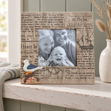 Load image into Gallery viewer, A rustic wooden photo frame with a collage of newspaper print, a black-and-white family portrait insert, a small blue-and-white bird ornament, and a rope detail, displayed on a white wooden shelf next to a vase with dried stems.