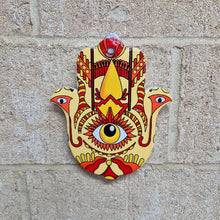 Load image into Gallery viewer, This multi-functional Hamsa Hand Of Protection serves as a trivet, plate, and hanging sign. Made from colorful ceramic, it adds a touch of charm to any kitchen or room. The Hamsa hand symbol offers protection and good luck, making it a meaningful and thoughtful gift.  In all faiths it is a protective sign. It brings it&#39;s owner happiness, luck, health, and good fortune.