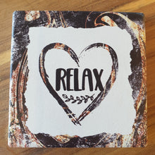 Load image into Gallery viewer, Relax - love heart hanging ceramic plaque and set of 4 boxed quality coasters.  A beautiful gift set for any home or office.  Relax Coasters Diameter - 10cm - Ceramic - Set of four - White gift box with lid - Cork backing - Four of same design as shown in photo.  Relax Hanging Plaque - 10 x 15 cm + Rope hanger -  Ceramic - Cork backing 