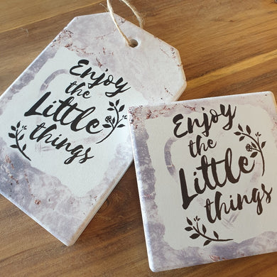 Enjoy The Little Things -  A Beautiful positive gift set of 1 x hanging plaque sign + 4 x ceramic coasters boxed.  Coasters - Diameter 10 cm - Ceramic - White gift box with lid - Cork backing - Set of 4   Hanging Plaque - 10 x 15 cm + rope hanger - Ceramic - Cork backing   It's always the little things in life that give us the most happiness.   View our whole shop today for more gift ideas - Keychains & Gifts Australia
