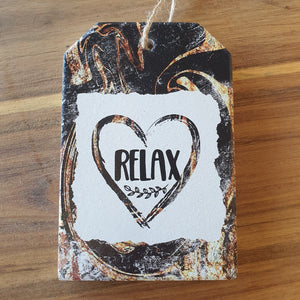 Relax - love heart hanging ceramic plaque and set of 4 boxed quality coasters.  A beautiful gift set for any home or office.  Relax Coasters Diameter - 10cm - Ceramic - Set of four - White gift box with lid - Cork backing - Four of same design as shown in photo.  Relax Hanging Plaque - 10 x 15 cm + Rope hanger -  Ceramic - Cork backing 