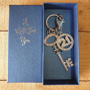 21st Birthday Celebration - key / bag chain and keepsake. Large silver crystal stone key, with 21st round symbol keepsake charm.  The perfect gift for that 21st special birthday. Boxed in our beautiful blue A Gift For You giftbox.   Boxed gift 6 x 14 cm - Silver rhinestones and key - View our store for more beautiful gifts Keychains & Gifts Australia.