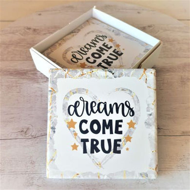 Transform any table into a positive space with our Dreams Come True Coasters. This set of 4 boxed coasters is a perfect gift for both table and bar settings. Let these coasters remind you that dreams do come true with every drink.  Ceramic | Cork backing | White gift box with lid | 10 x 10 cm | Set of 4 | Square