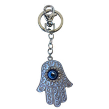 Load image into Gallery viewer, White Hand Of Protection ( Hand of Hamsa ) white / silver key bag chain.  The Hamsa Hand is a universal sign of protection, power and strength that dates back to ancient Mesopotamia. Known as the Hand of Fatima in Islam and Hand of Miriam in Judaism, it&#39;s believed to protect against against the evil eye and and all negative energies.