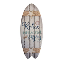 Load image into Gallery viewer, Our beautiful Relax Unwind Enjoy Beach range is the perfect gift for any beach house or ocean lover.  Relax Unwind Enjoy ceramic surfboards are the perfect gift. Use as a cheese board, hang or stand in your home.  Design is also available in coasters, hanging plaque&amp; magnets.  12 x 29 cm - Ceramic - Cork backing   Beach gift - Beach trivet - Beach décor gift - Beach Relax Surfboard