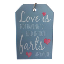 Load image into Gallery viewer, Love is not having to hold in your farts anymore funny ceramic hanging plaque sign. Give a gift of laughter.  10 x 15 cm - Ceramic - Cork backing - Rope hanger - Colours as shown in photo.  view our shop today for more quirky, funny gifts - Keychains &amp; Gifts Australia.  Fart gift - Funny gift - Love and fart gift.