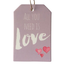 Load image into Gallery viewer, All you need is love pink hanging ceramic plaque sign.  A perfect gift to remind someone they are loved and all is OK when you have Love in your life.  10 x 15 cm + Rope Hanger - Cork backing - Ceramic   Free delivery on orders over $20 Australia wide - For orders under $20 a fee of $8.95 will apply at checkout.