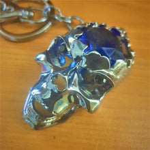 Load image into Gallery viewer, Skull lovers will love this hand made keychain skull.  Gun black metal | Skull 3.5 x 6 cm | Large blue rhinestone centre | Movable jaw | Full length of keychain 13 cm | Come in a cotton organza gift bag ready to gift.   Add this awesome skull gift to any set of keys - bag or hang in your car and let the beautiful blue rhinestone shine. 